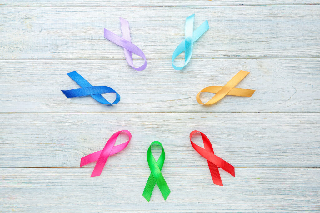 Different awareness ribbons on light wooden background
